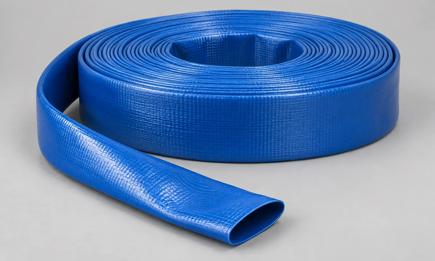 Blue PVC layflat hose coil with a flexible flattened end, product illustration